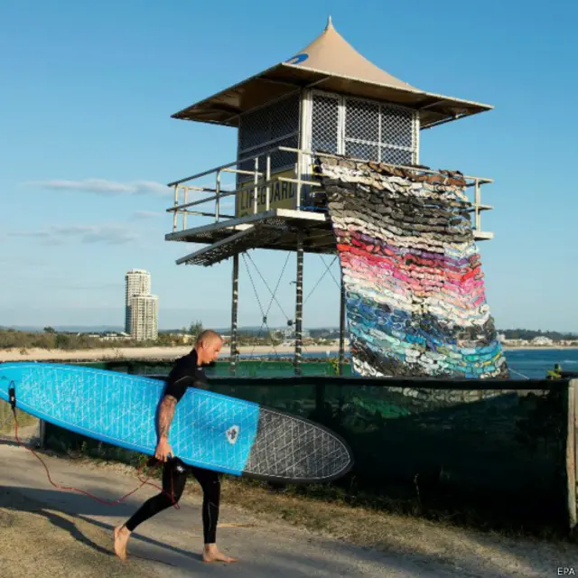 ऑस्ट्रेलिया के क्वींसलैंड प्रांत में कुरुकमबीन बीच पर इन दिनों एक ख़ास प्रदर्शनी लगी है. सालाना स्वेल स्कल्पचर्स फेस्टिवल में लगभग 50 कलाकृतियां मौजूद हैं. ऐसी ही एक कलाकृति के सामने से गुज़रता हुआ एक सर्फ़र.