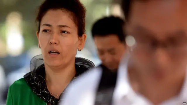 伊力哈木妻子古再丽•努尔（左）于午休后步行返回乌鲁木齐中级法院（17/9/2014）