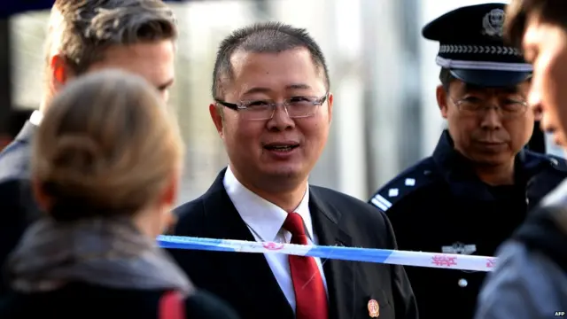 一名身穿法院制服的工作人员与封锁线外的外国驻华使馆官员交谈（17/9/2014）