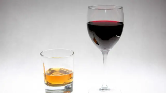 a glass of whisky and a glass of red wine