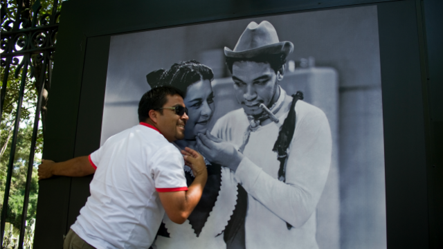 Un hombre posa ante la foto de Cantinflas en el centenario de su nacimiento. Foto: AFP/Getty