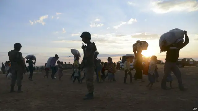Soldados turcos guardam fronteira com a síria enquanto refugiados sírios atravessam | Foto: AP