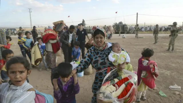 Refugiados sírios atravessam fronteira com a Turquia | Foto: AP