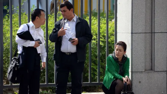 辯護律師李方平與伊力哈木的兄弟交談，旁邊是伊力哈木妻子。