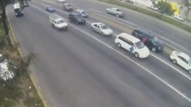 En esta foto del video tomado por una cámara de seguridad se puede ver a un hombre de camiseta roja junto a la camioneta Suburban donde viajaba el diputado, y a los vehículos rodeándola y bloqueándola
