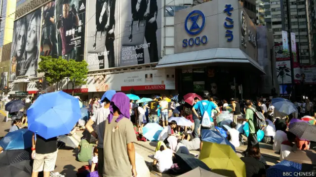 在铜锣湾崇光百货门前有不少示威人士和围观者（BBC中文网记者萧尔摄）