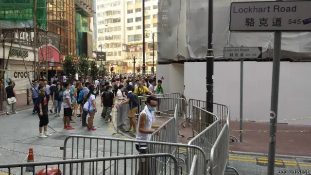 在铜锣湾骆克道，示威者将警方摆放的栅栏放在路口（BBC中文网记者萧尔摄）