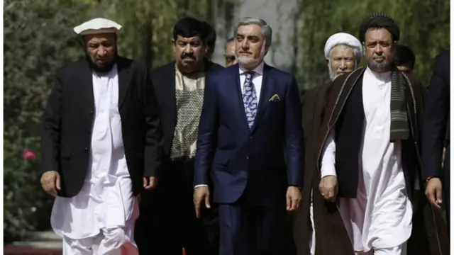 اشرف غني احمدزی په افغاني دودیزو کالیو او لونګۍ کې مراسمو ته راغلی، خو عبدالله عبدالله بیا دریشي اغوستې ده.