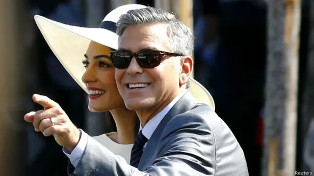 克鲁尼身穿一套炭灰色西装,新娘阿拉慕丁则身穿一件典雅的休闲白外套,头戴一顶宽边太阳帽。