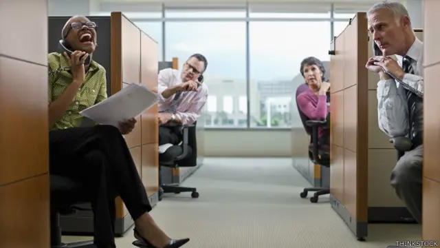 Trabajadores en cubículos molestos por compañera ruidosa