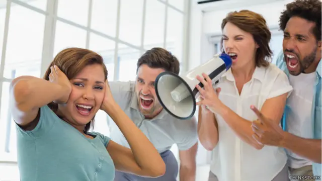 Trabajadora atormentada en una oficina ruidosa