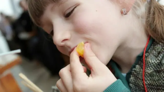 Niña comiendo mandarina