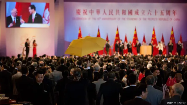 在国庆酒会祝酒期间,扣上黄丝带的前公民党成员司马文,在会场内打开了黄色的伞