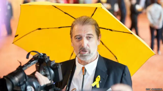 他向记者解释,以开伞代举杯,是要抗议政府用催泪弹对付示威者。