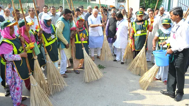 नई दिल्ली की वाल्मीकि बस्ती में प्रधानमंत्री नरेंद्र मोदी के साथ अन्य सफ़ाईकर्मि.