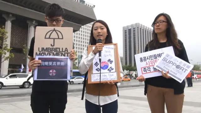 在韩香港人手持标语力挺占中示威 (摄影：杨虔豪)