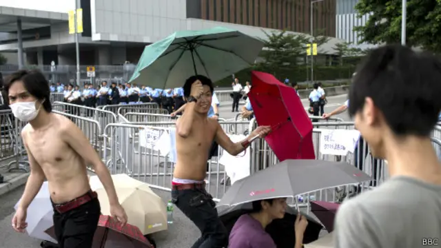 تظاهرکنندگان با چترهای خود که به سمبل مخالفت آنها تبدیل شده در خیابان های هنگ‌کنگ حضور دارند 