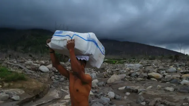 Seorang pengungsi memasuki wilayah berbahaya Gunung Sinabung pada September 2014.