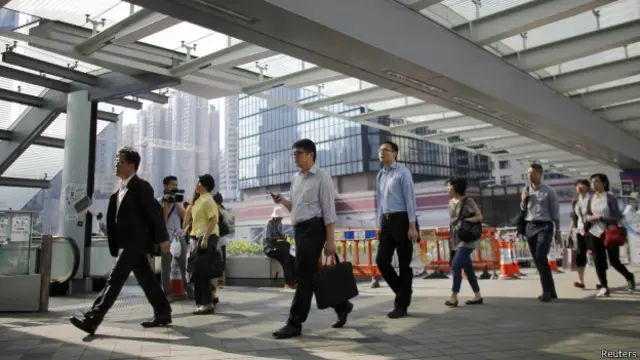 Люди идут на работу в правительственном квартале Гонконга