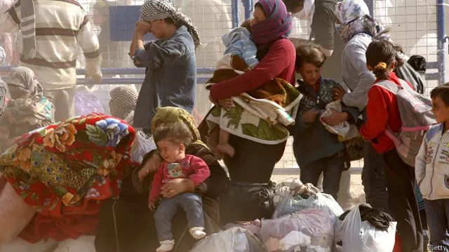 कोबानी की सीमा पर अपने सामान के साथ कुर्द विस्थापित