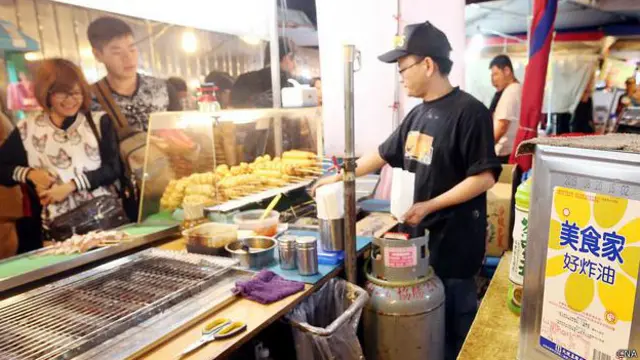 图为台北饶河夜市摊贩摆出使用检验合格炸油的油桶自清，让民众吃得安心