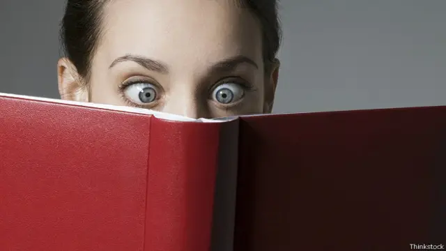 Девушка, читающая книгу в красной обложке