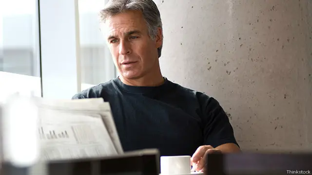 Мужчина читает газету в кафе