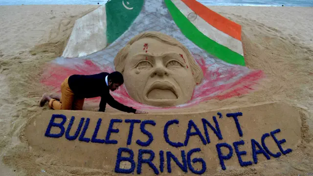 بھارت میں ریت کے مجسمے بنانے والے مشہور آرٹسٹ سندرسن پٹنائک اپنے تازہ مجسمے کو حتمی شکل دے رہے ہیں۔ اس مجسمے پر لکھا ہے ’گولیاں امن نہیں لا سکتیں‘۔