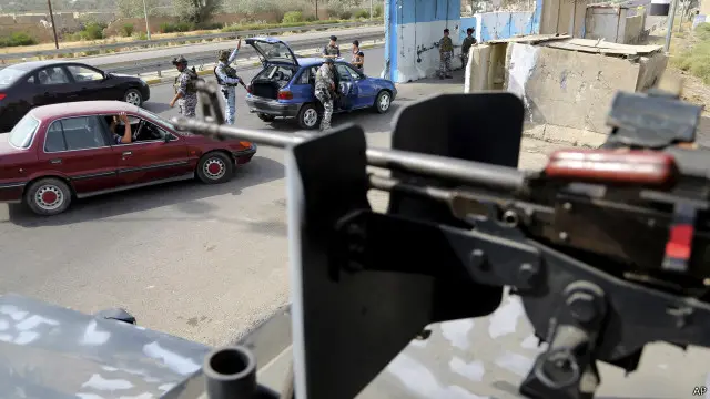 الشرطة الفيدرالية العراقية تفتش سيارة عند حاجز أمني في بغداد.