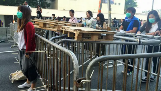 香港“占领中环”行动参与者在干诺道中中环段隔着剩余路障与警察对峙 （BBC中文网图片13/10/2014）