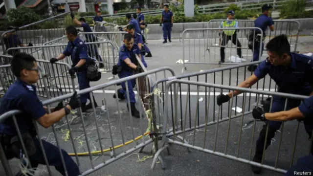 La policía retira vallas en Hong Kong.
