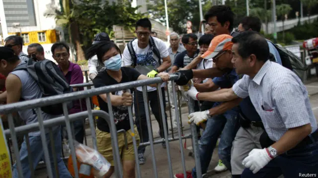 گروهی که ماسک جراحی به صورت داشتند با تظاهرکنندگان درگیر شدند