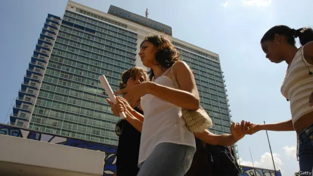 Jóvenes cubanos pasan por delante del hotel Habana Libre.