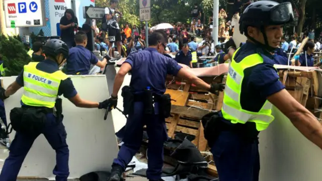 香港警方在金鐘道清理「佔領中環」示威者架設的路障和雜物（BBC中文網圖片14/10/2014）