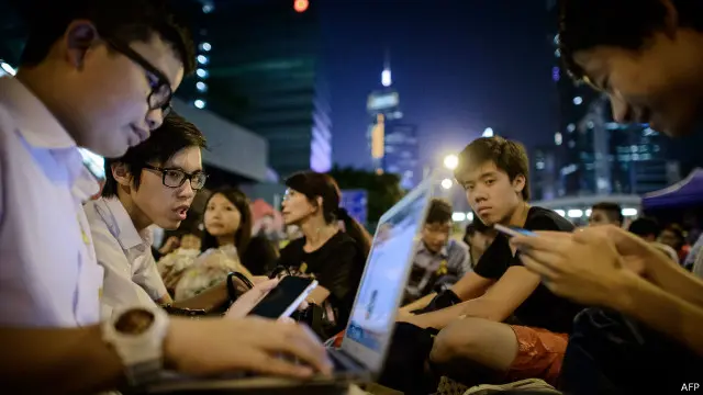طلاب يتصفحون أجهزة كومبيوتر محمول وهواتف ذكية خلال مشاركتهم في احتجاجات هونغ كونغ.