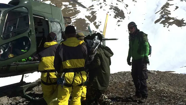 घटना में मारे गए ट्रैकर का शव हेलिकॉप्टर में लादते बचाव कर्मी