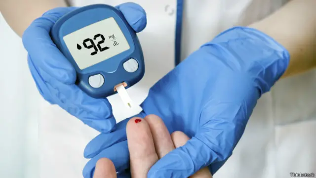 Persona midiendo la glucosa en la sangre con un aparato.