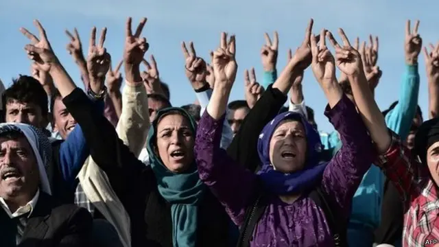 وقفت جموع من الأكراد تهتف هتافات مناهضة لتنظيم الدولة الإسلامية فوق التلال التركية المطلة على البلدة