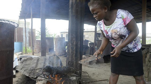 Mujer asando carne silvestre