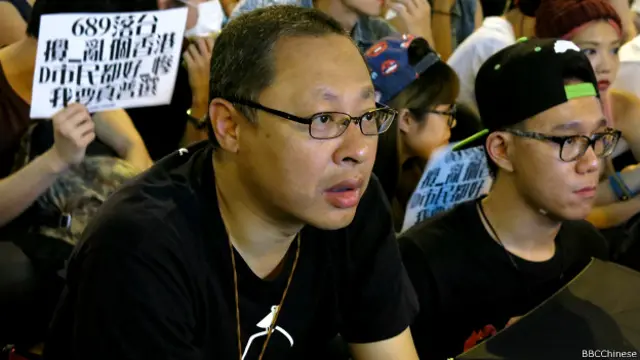 “占中三子”之一戴耀廷坐在前排，聚精会神收看直播。