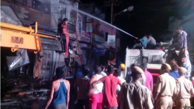 घटनास्थल पर आग बुझाते लोग