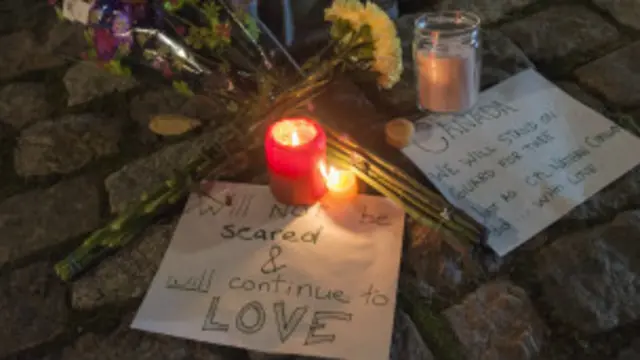 वॉर मेमोरियल के पास लोग फूल भेंट करते हुए