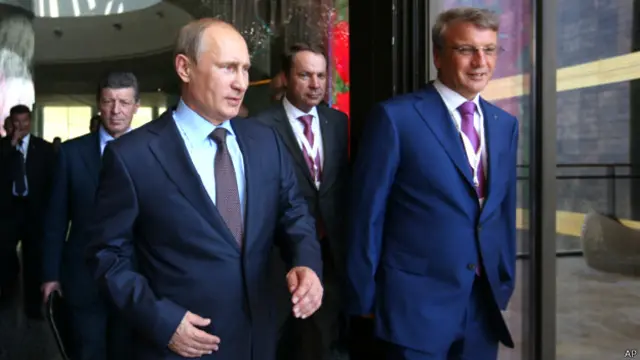 Еще в июле Сбербанк (президент Сбербанка Герман Греф - справа) раскритиковал введеные против него Евросоюзом санкции, заявив, что не влияет на текущие "геополитические процессы"