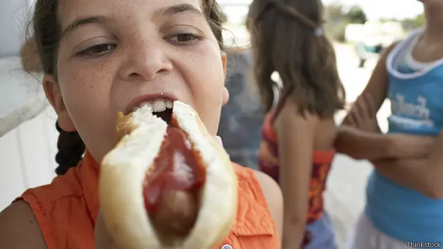 Девочка ест хот-дог