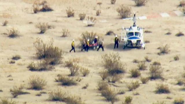 Petugas membawa seorang yang terluka ke helikopter yang akan mengangkutnya ke rumah sakit.