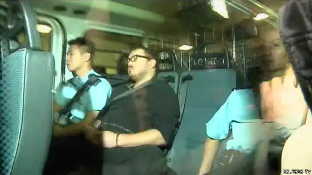 Rurik Jutting yang duduk di mobil polisi datang di pengadilan dengan dakwaan pembunuhan.