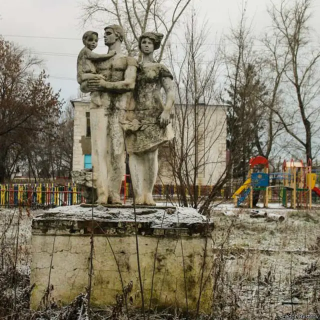 Федор Быстров сделал эту фотографию во время экспедии по российским селам в рамках проекта "Уникальная глубинка": "В деревне Нижнее Санчелеево Самарской области мы обнаружили заброшенный парк, в котором стоит этот памятник семье. Интересно, что памятник был создан по проекту бывшего председателя колхоза Владимира Ивановича Карпова (его уже нет в живых). Точный год установки никто не помнит - приблизительно 1970 - 1975 гг. Симптоматично, что за заброшенным памятником находится здание действующего детского сада".