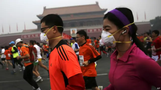 北京马拉松几名选手带着口罩跑过天安门城楼（19/10/2014）