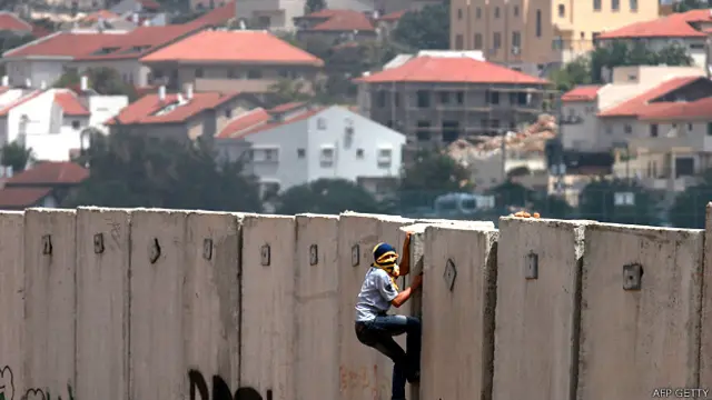 Joven palestino intenta escalar el muro en Cisjordania