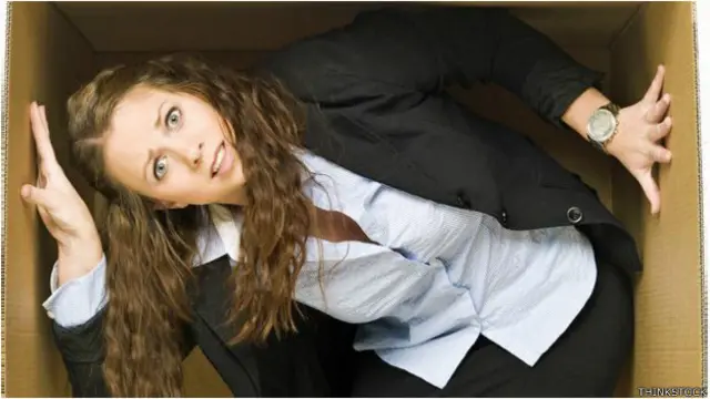 Una empleada dentro de una caja de cartón